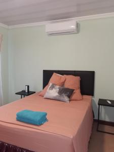 a bedroom with a large bed with orange sheets at A home away from home in Nelspruit