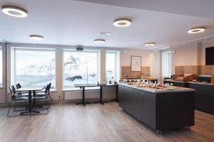 a large kitchen with a table and chairs and windows at The View in Honningsvåg