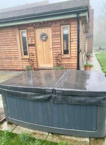 a large bathtub in front of a house at Quality Oak Barn with Hot Tub and Parking in Bramley