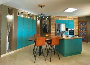 a kitchen with blue cabinets and a wooden table at KABEN Superbe villa prestige 4 étoiles, sauna, jacuzzi, pétanque, sans vis à vis in Saint-Geniès-de-Fontedit
