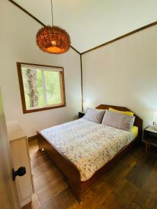 a bedroom with a bed and a window at Carpinterito cabaña, ensenada campestre in Puerto Varas