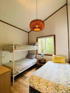 a bedroom with two bunk beds and a chandelier at Carpinterito cabaña, ensenada campestre in Puerto Varas