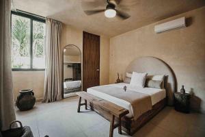 a bedroom with a large bed and a ceiling fan at Casa Pacha Alma Tulum - Jungle Villa in Tulum