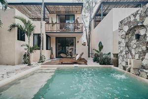 a house with a swimming pool in front of a house at Casa Pacha Alma Tulum - Jungle Villa in Tulum