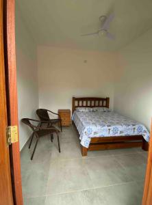 Un dormitorio con una cama y una silla dentro. en Suítes Kauai, en São Sebastião 8 fotos más