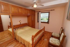 een slaapkamer met een bed en een plafondventilator bij Seaside Apartments Markota in Blato