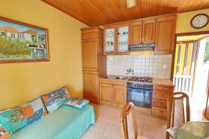 a kitchen with a couch and a stove top oven at Seaside Apartments Markota in Blato