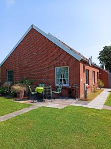 a brick building with a table and chairs in front of it at Up Höcht in Osteel