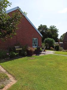 a red brick building with a grass yard at Up Höcht in Osteel