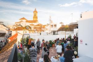 a crowd of people standing around in front of a building at Veranera Hostel in Estepona