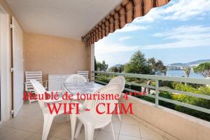 un balcone con tavolo e sedie e vista sull'acqua di Bel appartement vue mer ad Agay - Saint Raphael