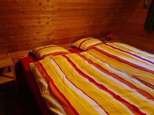 two beds in a bedroom with a wooden wall at Haus Gimpel Flumserberg in Flumserberg