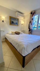 アゲにあるBel appartement vue merのベッドルーム(白いシーツを使用した大型ベッド1台付)