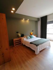 ein Schlafzimmer mit einem großen Bett und Holzboden in der Unterkunft Arona 03 centralissimo ampio bilocale con garage in Arona