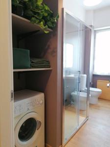 eine Waschküche mit einer Waschmaschine und einer Glastür in der Unterkunft Arona 03 centralissimo ampio bilocale con garage in Arona