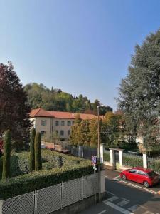a red car driving down a street with a fence at Arona 03 centralissimo ampio bilocale con garage in Arona +23 photos