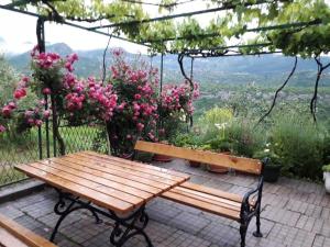 a wooden bench sitting on a patio with flowers at Holiday Home Carević in Gornja Brela