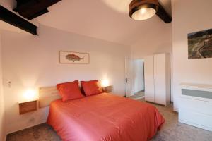 a bedroom with a large orange bed with two pillows at Appartements à la ferme in La Ciotat