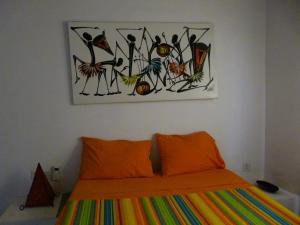 una camera da letto con un letto e un dipinto sul muro di La CASETTA A ZANZIBAR B&B a Uroa