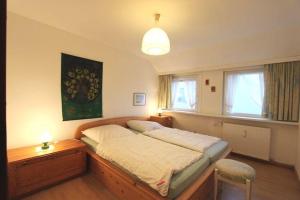 a bedroom with a bed and a desk and window at Seewarte in Hörnum