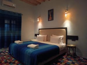 une chambre avec un lit avec deux serviettes dessus dans l'établissement kasbah Dar Bahnini, à Skoura