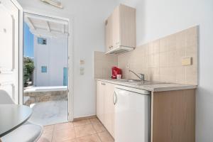 a white kitchen with a sink and a shower at Ornos Apartments in Ornos +19 photos