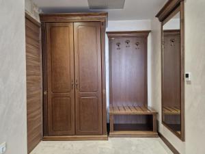 um closet com armários de madeira e um espelho em СПА Комплекс Свети Георги 
