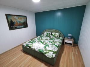 a bedroom with a bed and a painting on the wall at Noah Apartment in Uricani