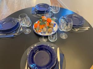 a table with blue plates and wine glasses on it at LOFT sull'acqua con vista mozzafiato in Naples +22 photos