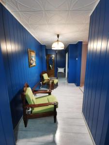 a hallway with blue walls and chairs in a room at Noah Apartment in Uricani