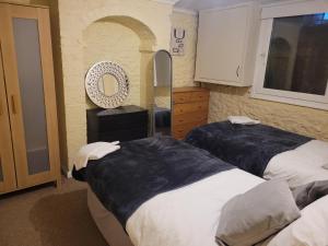 een slaapkamer met 2 bedden, een spiegel en een wastafel bij Comfortable 2 bedroom property, Maidstone in Maidstone