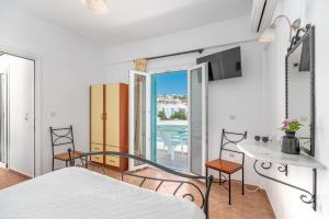 a bedroom with a bed and a balcony at Ornos Apartments in Ornos