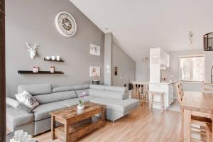 ein Wohnzimmer mit Sofa und Tisch in der Unterkunft Le Cozy-Condo à louer à Stoneham (CITQ 239956) in Stoneham