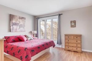 ein Schlafzimmer mit einem Bett, einer Kommode und einem Fenster in der Unterkunft Le Cozy-Condo à louer à Stoneham (CITQ 239956) in Stoneham