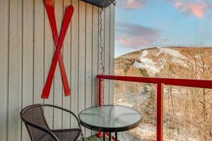 ein Tisch und Stühle auf einem Balkon mit Axt-Schild in der Unterkunft Le Cozy-Condo à louer à Stoneham (CITQ 239956) in Stoneham + 16 Fotos