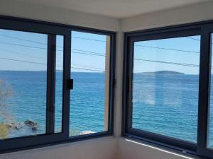 a room with two windows looking out at the ocean at Blaža in Prvić Luka