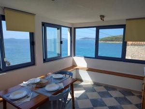 - une salle à manger avec une table et une vue sur l'océan dans l'établissement Blaža, à Prvić Luka