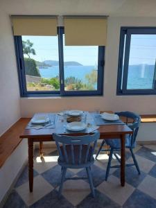 - une salle à manger avec une table et des chaises offrant une vue sur l'océan dans l'établissement Blaža, à Prvić Luka