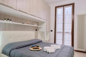 ein Schlafzimmer mit einem blauen Bett und weißen Handtüchern in der Unterkunft [Seveso-Stazione] Design, Wifi & Garage Privato in Seveso
