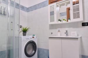 eine Waschküche mit einer Waschmaschine und einem Waschbecken in der Unterkunft [Seveso-Stazione] Design, Wifi & Garage Privato in Seveso