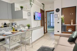 eine Küche und ein Wohnzimmer mit einem Tisch und einem Sofa in der Unterkunft [Seveso-Stazione] Design, Wifi & Garage Privato in Seveso
