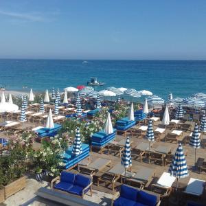 a beach with chairs and umbrellas and the ocean at Chill Out Apartment, 2 mins from beach in Nice