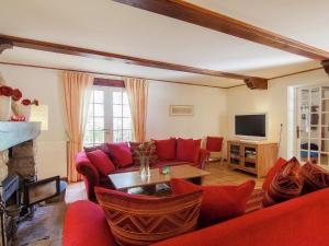 een woonkamer met een rode bank en een tv bij Villa les Bois 10 pers in Bouzic