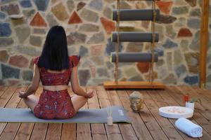 uma mulher sentada no chão numa pose de yoga em Paradise Apartments em Ferma