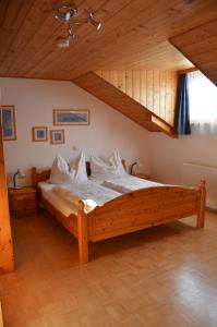 uma grande cama de madeira num quarto com tecto de madeira em Rauterhof em Hermagor