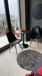 een kamer met twee stoelen, een tafel en een raam bij Villa Residence Apartment in Tbilisi City +6 foto's