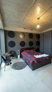 een slaapkamer met een bed, een tafel en stoelen bij Villa Residence Apartment in Tbilisi City