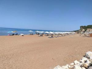 a beach with chairs and umbrellas and the ocean at Spiros full House in Marathias in Marathias