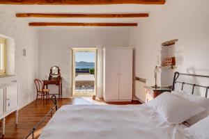 a bedroom with a bed and a table and a chair at Villa Danae by the sea in Pounda