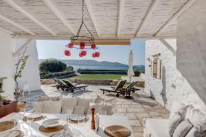 a patio with a table and chairs and a view at Villa Danae by the sea in Pounda +43 photos